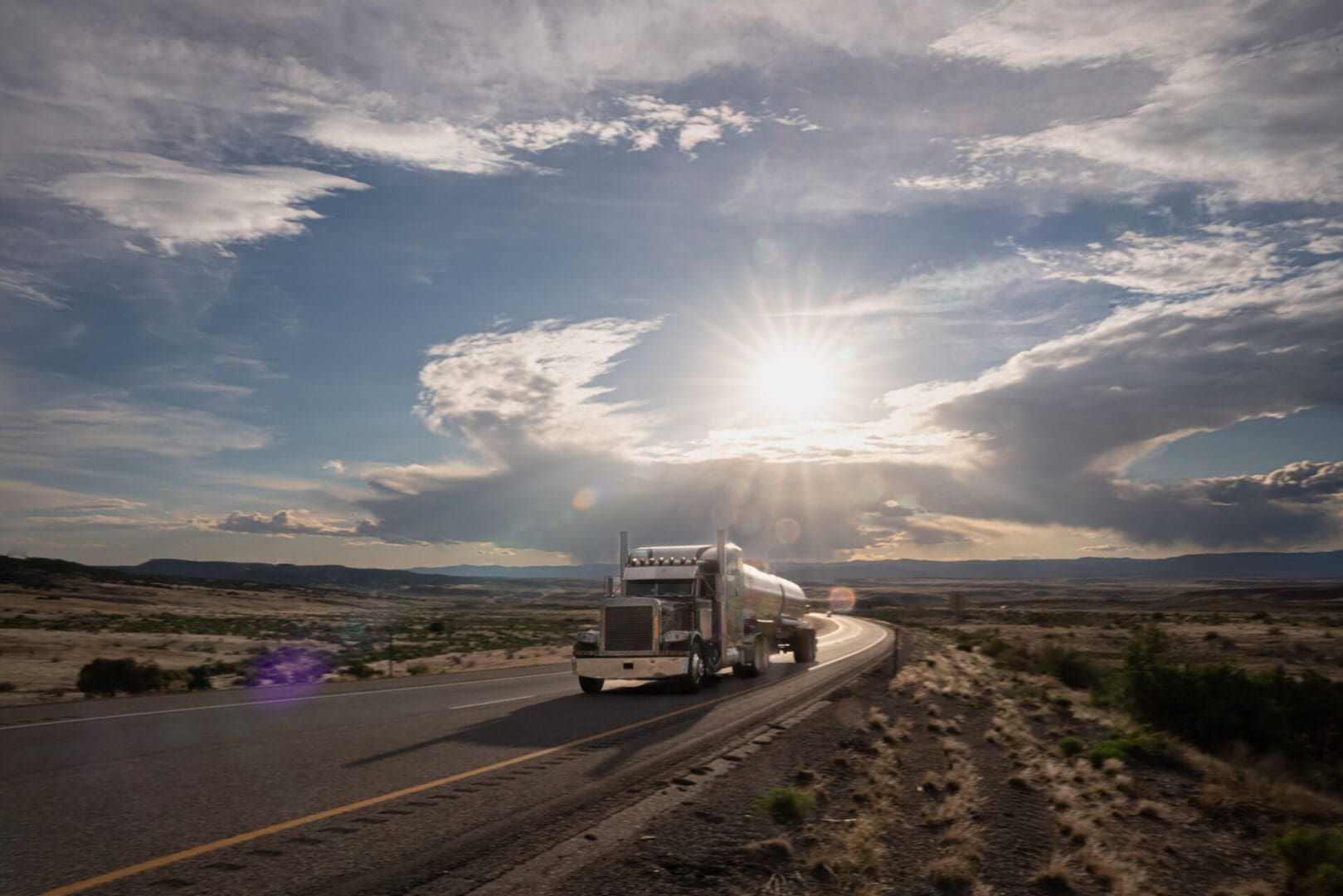 Truck driving on a desert highway.