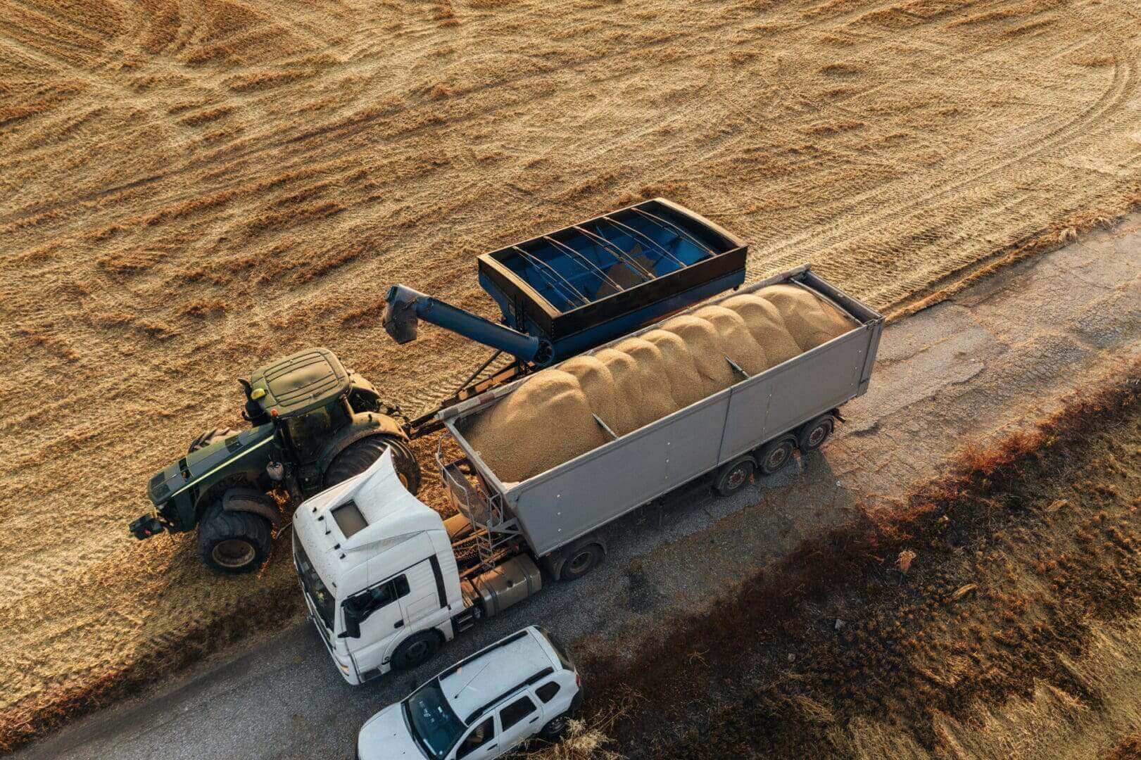 Aerial view of tractor unloading grain into trailer
